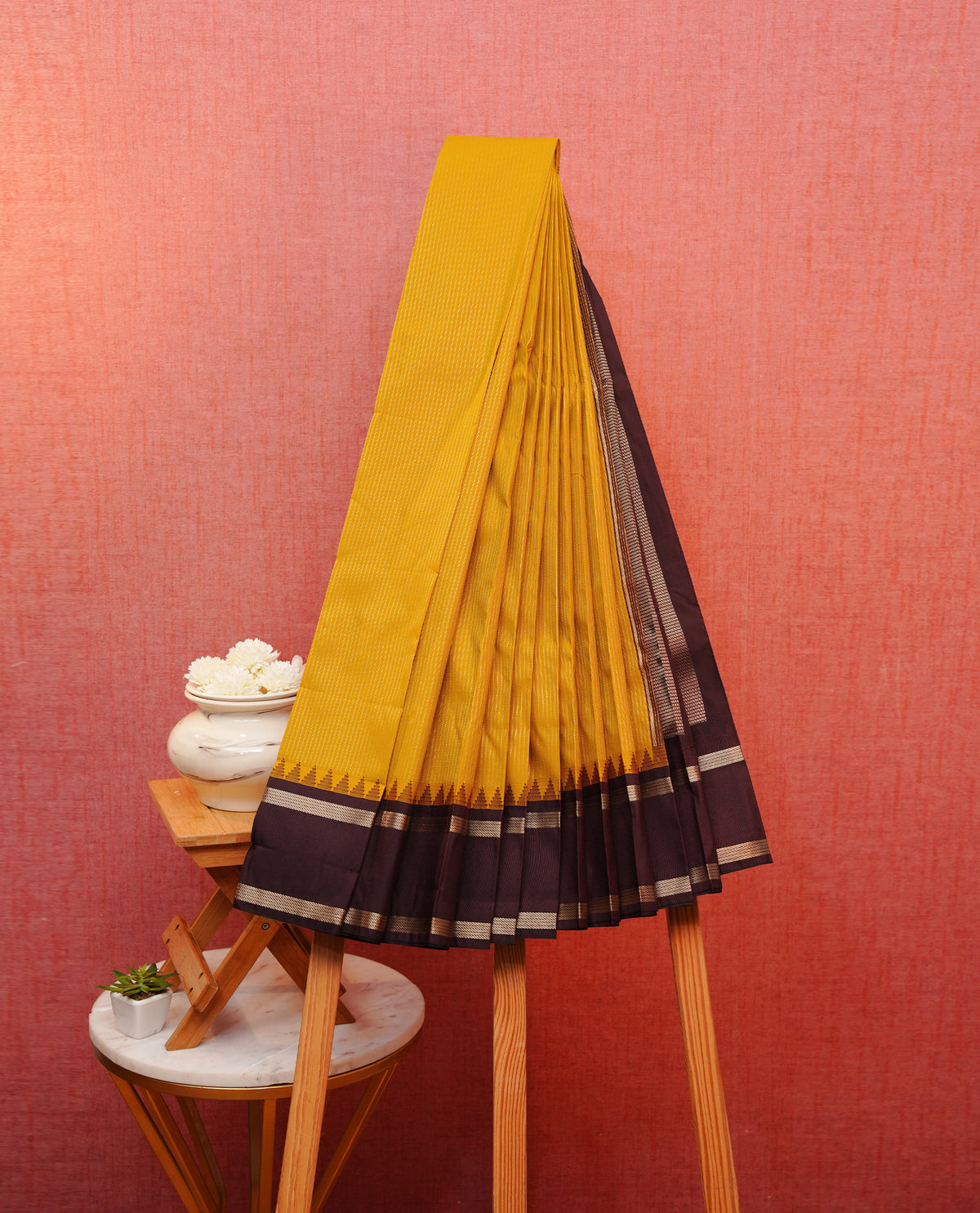 Mustard yellow colour soft silk saree featuring gold zari stripes on body, contrast dark chocolate colour gold zari simple border, grand pallu comes with matching blouse piece.