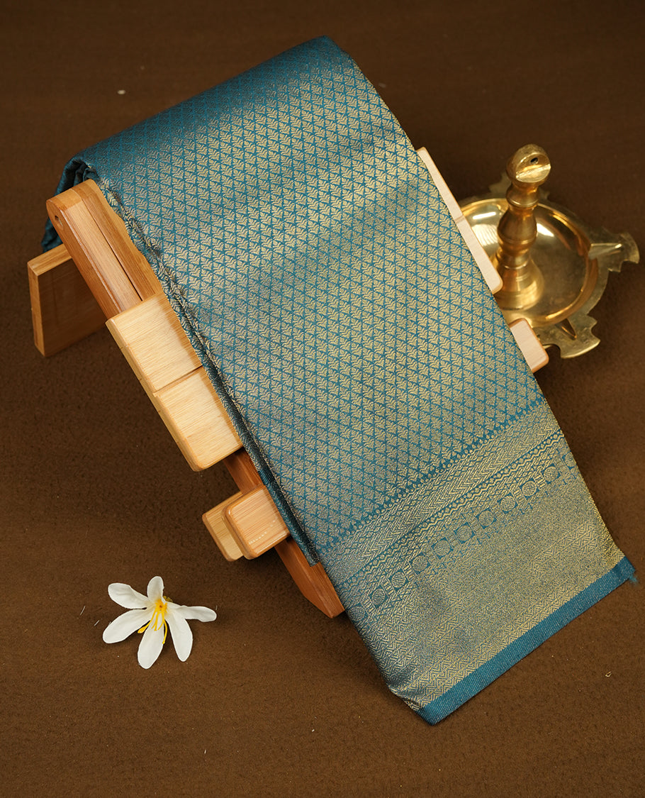Teal colour semi soft silk saree featuring gold zari floral motifs on across body, self colour border with traditional gold zari pattern, pallu and paired with matching blouse.