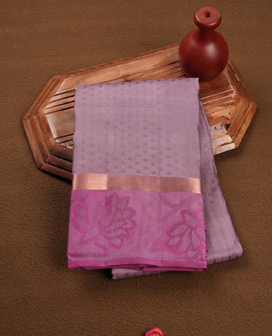 Dusty lavender colour soft silk saree featuring gold zari motifs on the body, complemented by a contrast magenta traditional zari floral kodi border and pallu, paired with a matching blouse piece.