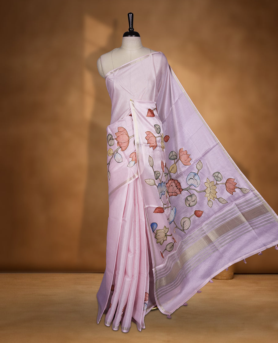 Pastel Pink colour semi tusser silk saree featuring delicate hand painted floral motifs along the pallu and border finished with subtle tassels and paired with a matching blouse.