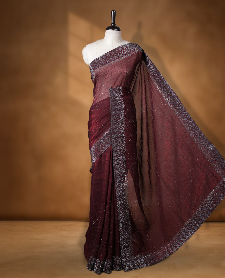 Chocolate brown colour chiffon designer saree, featuring white stone all over on body, heavy stone patttern on border and  pallu, Paired with matching blouse.