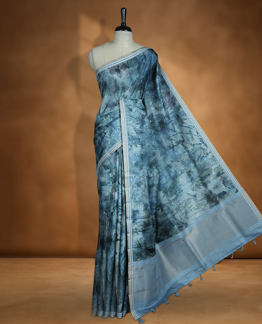 Dark Green colour semi tussar silk saree featuring an abstract floral printed body with a rich self border and tasselled pallu, paired with a matching blouse.