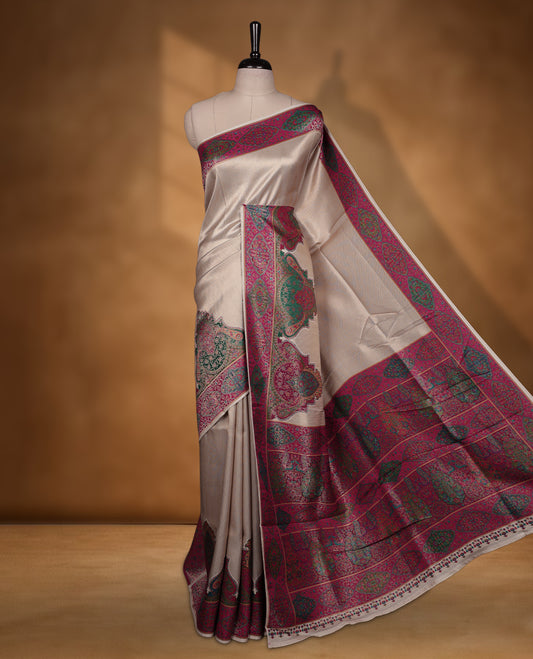 Beige colour Pashmina silk saree intricately woven with Mughal inspired garden scenes and figurative motifs across the body, framed by a rich maroon storytelling border and grand pallu, paired with a coordinated maroon woven jaal blouse piece (Copy)