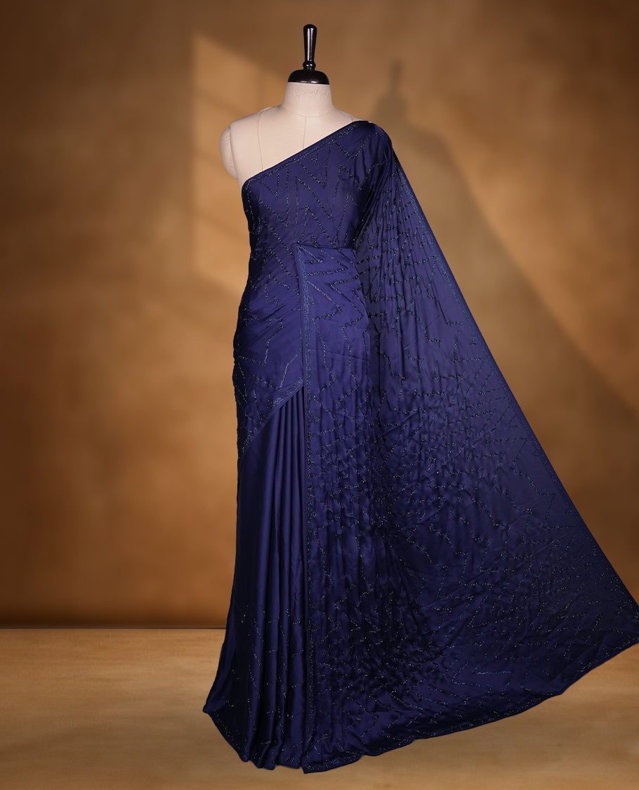 Dark blue colour chiffon fancy saree featuring white Self colour beats stripped pattern on body and detailing on the border and paired matching blouse.