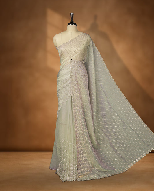 Gray and pink double shade Colour net shimmer fancy saree adorned with scattered white stone buttas all over the body, paired with a delicate stone worked border and matching blouse
