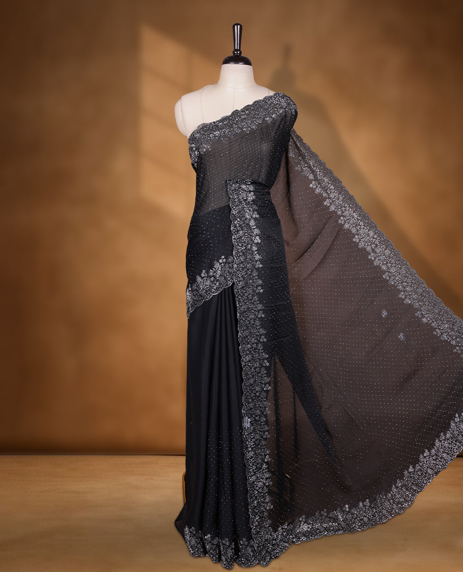 Black colour shimmer designer saree, featuring white scattered stone on body, stone work and heavy stone floral pattern on border and  pallu, Paired with matching blouse.