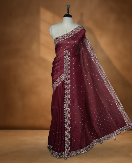 Maroon Colour Shimmer Designer Saree featuring Delicate White Stone Scattered Work on the Body, enhanced with Intricate Stone Detailing on the Border and Pallu, paired with a Matching Blouse.