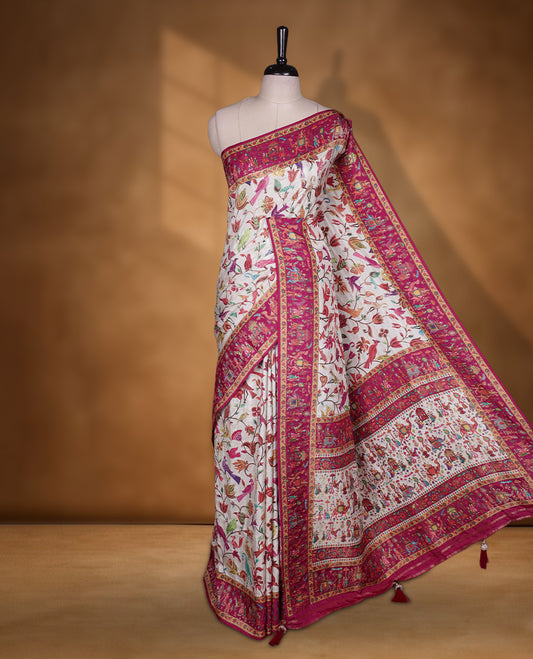 Ivory colour Pashmina silk saree intricately woven with multicolour birds and floral vines on the body, framed by a vibrant pink zari border and grand storytelling pallu with royal procession motifs, paired with a matching woven border blouse piece.