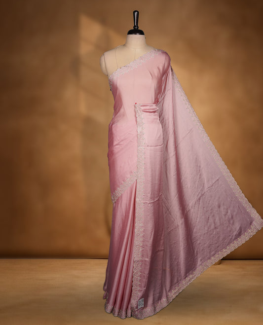 Light Pink colour chiffon designer saree featuring delicate silver stone embellishments along the border and pallu, paired with a matching embellished blouse.