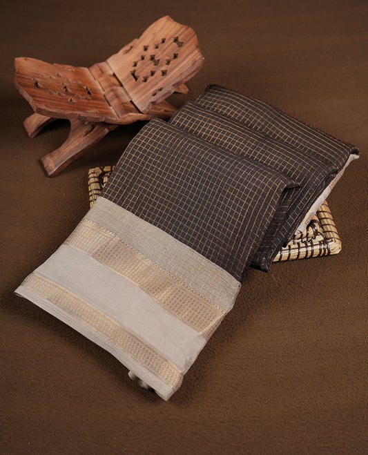 Deep Brown colour saree featuring fine check patterns on the body, paired with a contrast zari woven border and pallu. Comes with a matching blouse piece