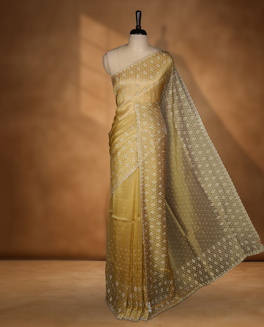 Gold Colour Shimmer Designer Saree featuring Delicate gold Stone Scattered Work on the Body, enhanced with Intricate Stone Detailing on the Border and Pallu, paired with a Matching Blouse.