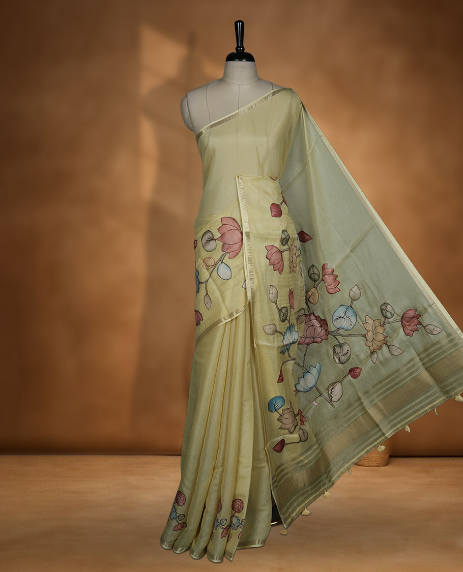 Pastel yellow colour semi tusser silk saree featuring delicate hand painted floral motifs along the pallu and border finished with subtle tassels and paired with a matching blouse.
