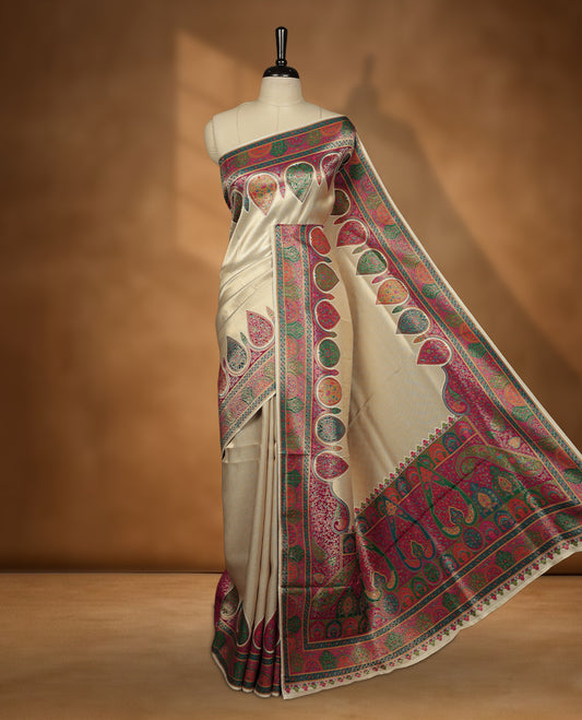 Ivory colour Pashmina silk saree featuring a sleek plain body, accentuated with an opulent multicolour paisley and floral panelled border and grand pallu, paired with a contrasting magenta woven jaal blouse piece.