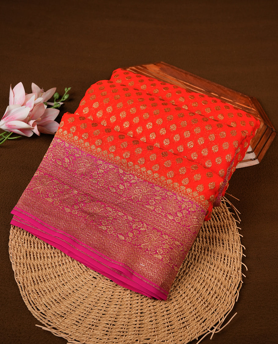 Orange colour pure Banarasi Crepe saree featuring Antique zari Flower Motifs all over the body, complemented by an contrast Pink dye colour with gold zari Floral Kodi Worked border and pallu, with matching blouse.