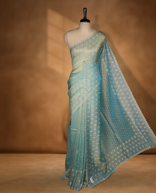 Light blue Colour Shimmer Designer Saree featuring Delicate White Stone Scattered Work on the Body, enhanced with Intricate Stone Detailing on the Border and Pallu, paired with a Matching Blouse.