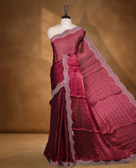 Burgundy colour chiffon designer saree, featuring self colour beats stripes on body, heavy gold stone patttern on border and  pallu, Paired with matching blouse.