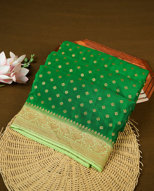 Dark Green colour pure Banarasi georgette saree featuring gold zari Flower Motifs all over the body, complemented by an contrast Light green dye colour with gold zari Floral Kodi Worked border and pallu, with matching blouse.
