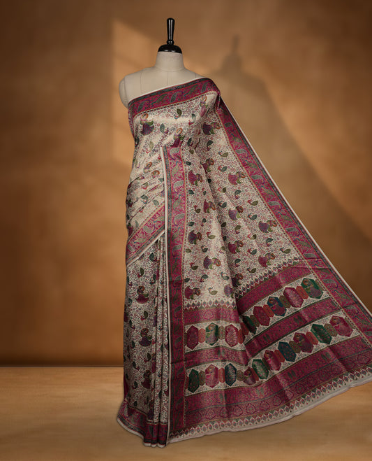 Ivory colour Pashmina silk saree richly woven with all over multicolour dancing figurines and paisley motifs, highlighted by a vibrant pink & green zari border and grand panelled pallu, paired with a matching woven border blouse piece.