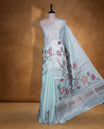 Light aqua blue colour semi tusser silk saree featuring delicate hand painted floral motifs along the pallu and border finished with subtle tassels and paired with a matching blouse.