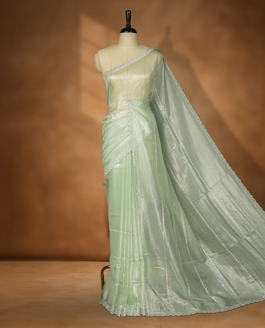 Mint Green Colour net shimmer fancy saree adorned with strip white stone buttas all over the body, paired with a delicate stone worked border and matching blouse
