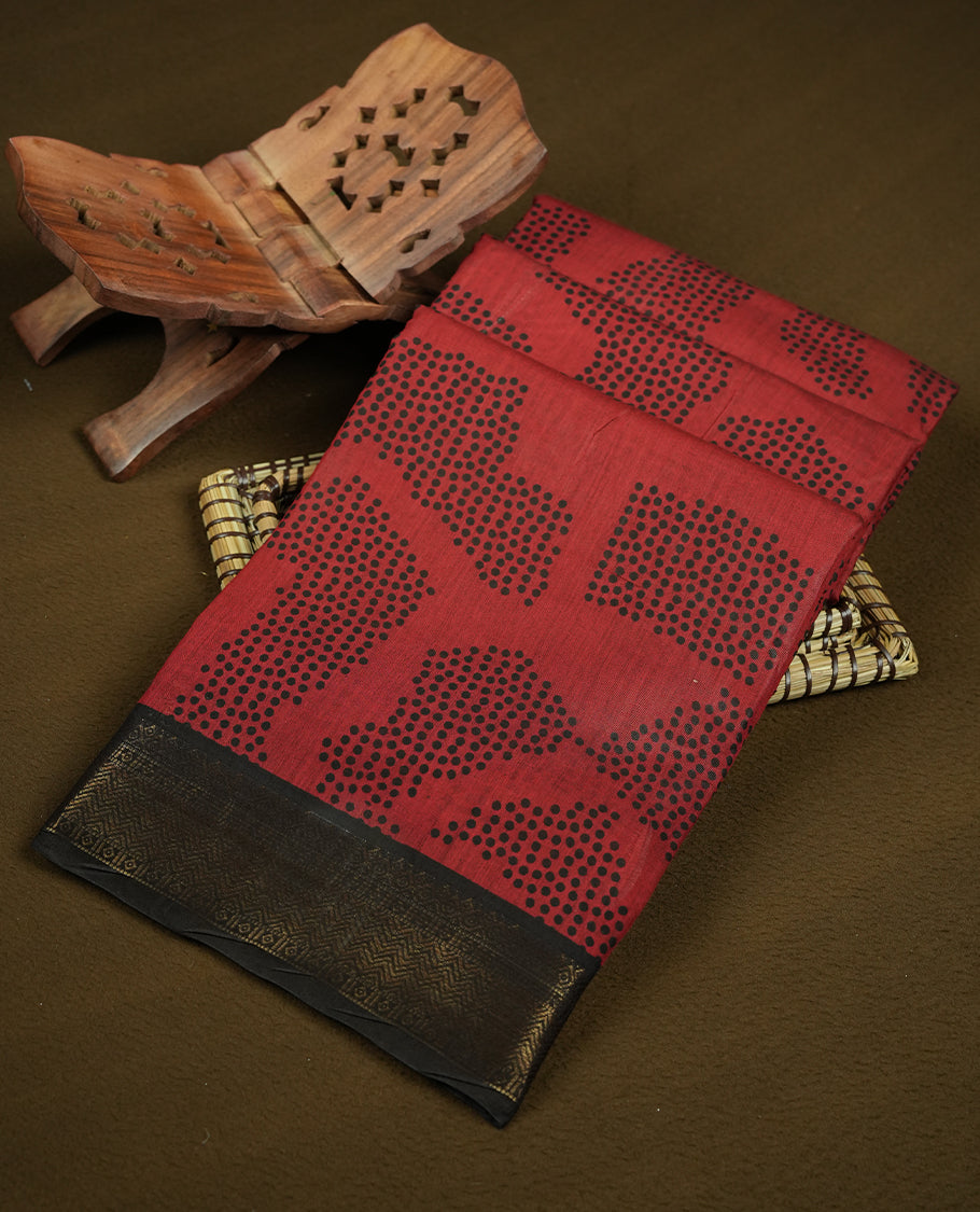 Coral red colour mixed chanderi cotton saree featuring black dot printed body, striped pallu with black and red geometric patterns, golden zari border, and matching blouse
