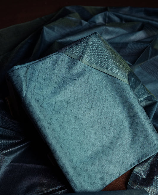 Teal blue colour churidhar material featuring elegant self jacquard design on the body, complemented by a rich woven border & Comes with a matching dupatta with tassels and plain bottom.