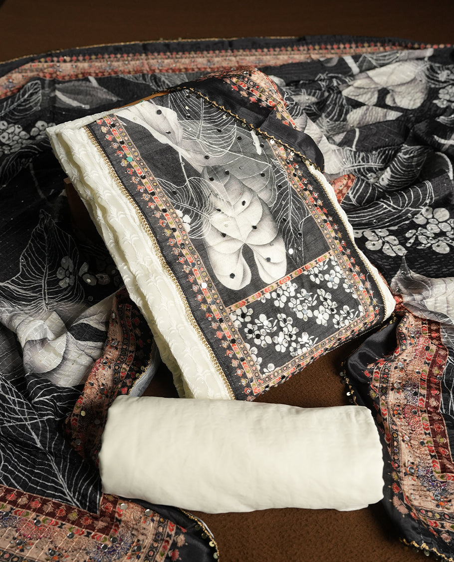 Off white colour churidhar material featuring Mirror and thread embroidery, foral print pattern on the contrast black colour front panel, floral digital printed dupatta with elegant border, and matching plain bottom