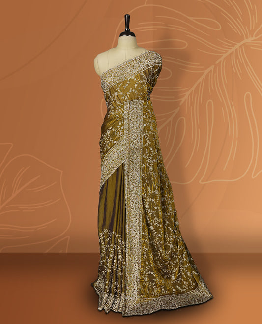 Mustard yellow colour velvet chiffon designer saree in elegant two tone shades, featuring light gold zari, kodi work with handwoven style thread embroidery, Swarovski stone work and all over motifs, comes with matching blouse.