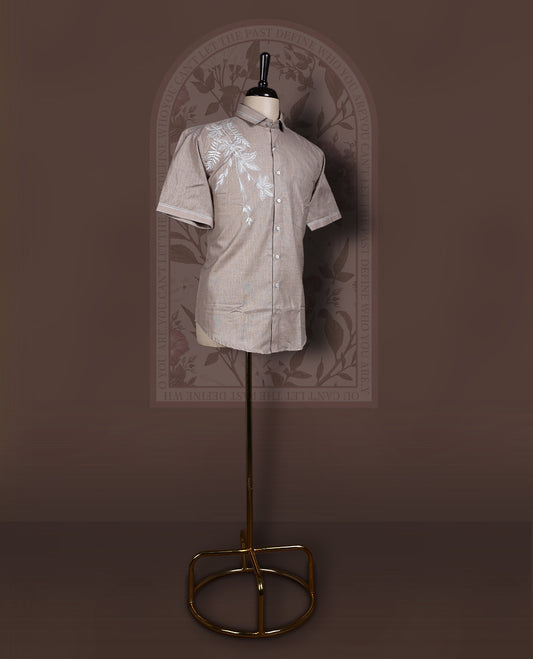 Taupe colour cotton linen short sleeve shirt featuring delicate white floral embroidery on the shoulder, Designed with a classic collar and button down front, offering a stylish blend of comfort and elegance.