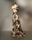 Beige colour pure crepe saree with abstract floral print in earthy tones, highlighted by mirror work on the body and scalloped border, paired with a matching blouse.