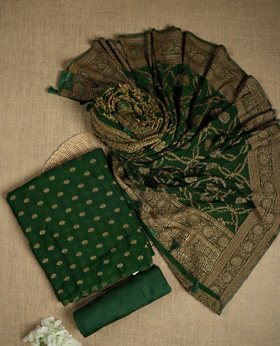 Royal Green suit material adorned with intricate golden toned zari motifs weaving, exuding timeless elegance & Paired with a beautifully woven dupatta featuring floral and motifs and a matching plain bottom.