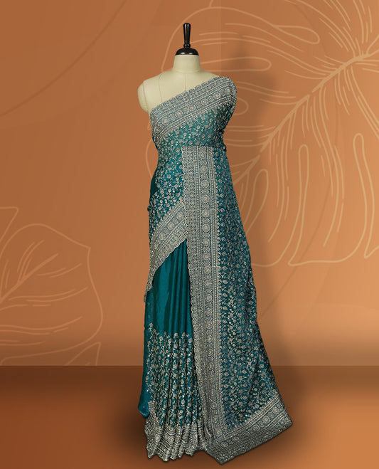 Sky blue colour velvet chiffon designer saree in elegant two tone shades, featuring light gold zari, kodi work with handwoven style thread aari & dori embroidery work, Swarovski stone work and all over motifs, comes with matching blouse.