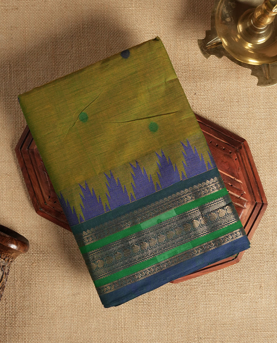 Olive green & Blue dual shaded Chettinad cotton saree adorned with small woven dots on the body, saree features a striking blue and green border with intricate golden zari patterns and geometric motifs & Comes with a matching blouse piece.