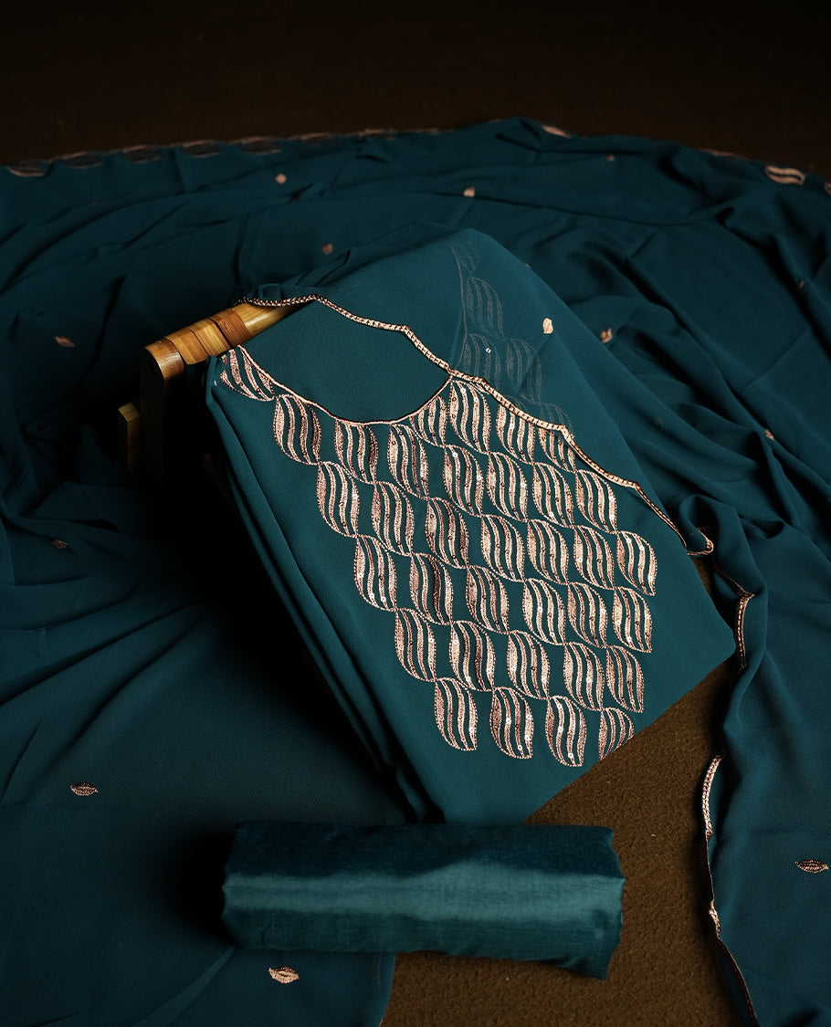 Teal blue colour churidar material adorned with intricate sequin embroidery on the neckline and body & dupatta comes with embroidered motifs and matching scalloped embroidered border & and plain bottom.