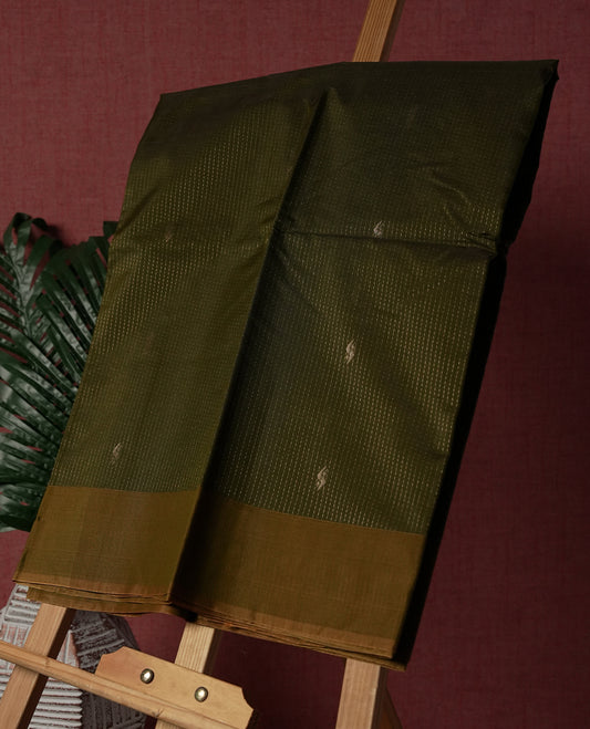Olive green colour pure handloom cotton saree featuring fine golden stripes with delicate motifs, paired with a rich zari border for a traditional yet elegant look, perfect for graceful occasions & Comes with matching blouse.