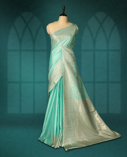 Sea green colour semi silk saree featuring delicate golden zari floral motifs across the body, complemented by a rich self colour woven border and pallu, paired with a matching blouse.