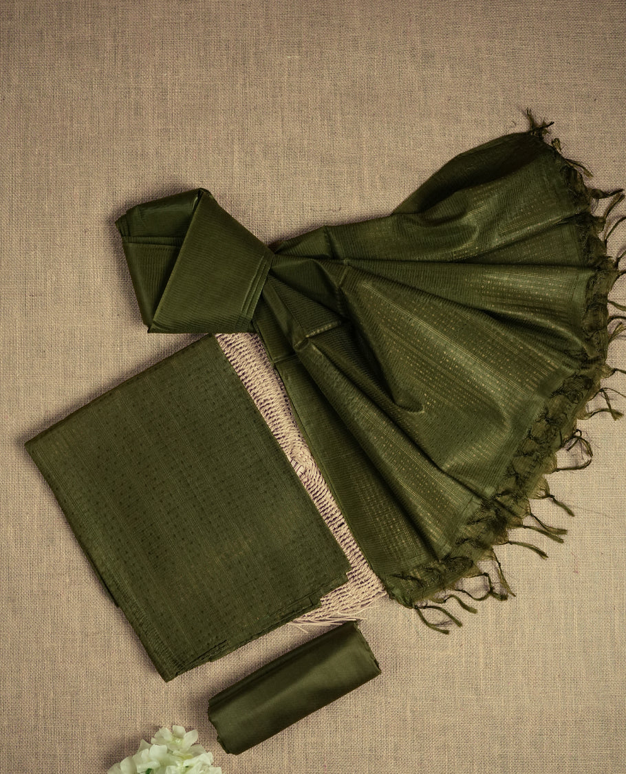 Dark Army green colour tussar suit material featuring a subtle self copper zari woven motifs and vertical and stripped pattern on the body, paired with a lightweight matching dupatta with tassel edges and a plain bottom piece.