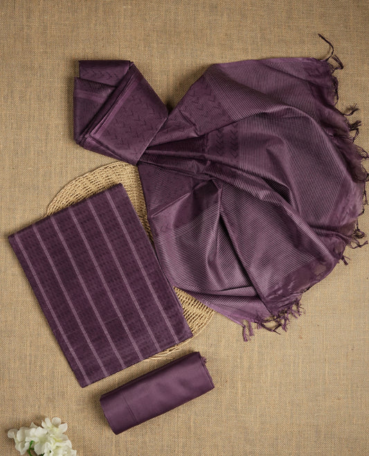 Dark lavender tussar suit material featuring a subtle self woven pattern and vertical lines on the body, paired with a lightweight matching dupatta with tassel edges and a plain bottom piece.