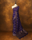 Indigo Banarasi Bandhani saree with golden zari motifs in checkered Bandhani body, detailed zari woven border, and rich pallu with tassels. A perfect blend of tradition and festive grace.