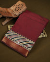 Maroon colour chanderi cotton saree with plain body, geometric tribal printed pallu with golden zari border, and diagonal striped blouse.