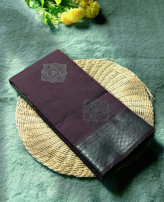 Wine colour silk cotton saree adorned with a shimmering silver zari border and intricate woven designs, blending elegance with tradition, Paired with a matching blouse, its perfect for festive and special occasions.