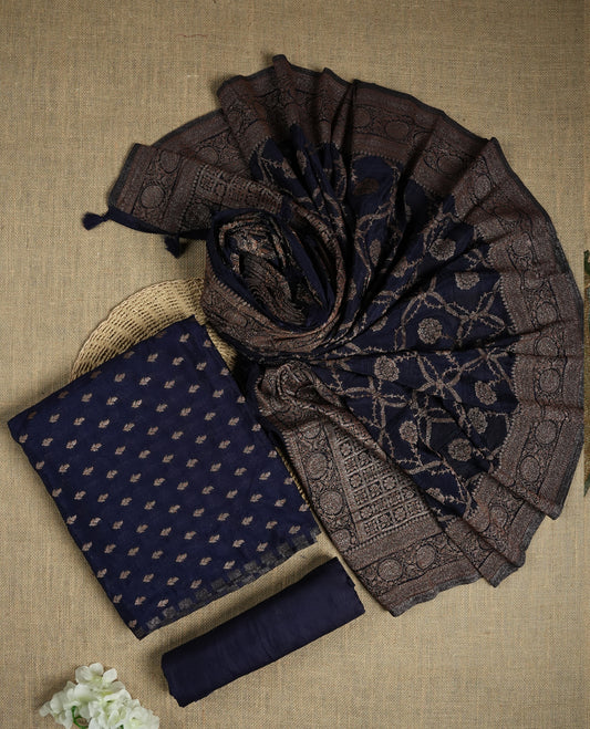 Navy blue suit material adorned with intricate light copper toned zari motifs weaving, exuding timeless elegance & Paired with a beautifully woven dupatta featuring floral and motifs and a matching plain bottom.