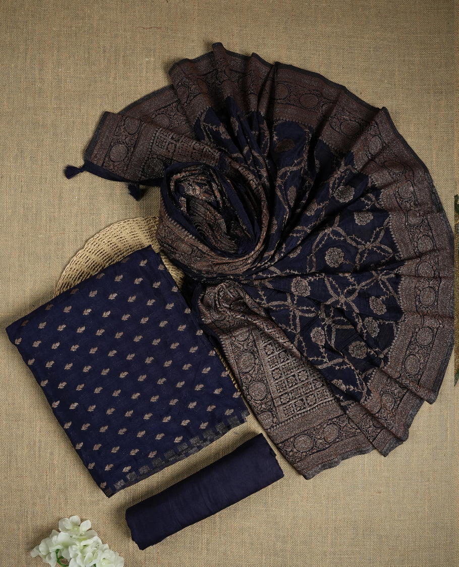 Navy blue suit material adorned with intricate light copper toned zari motifs weaving, exuding timeless elegance & Paired with a beautifully woven dupatta featuring floral and motifs and a matching plain bottom.