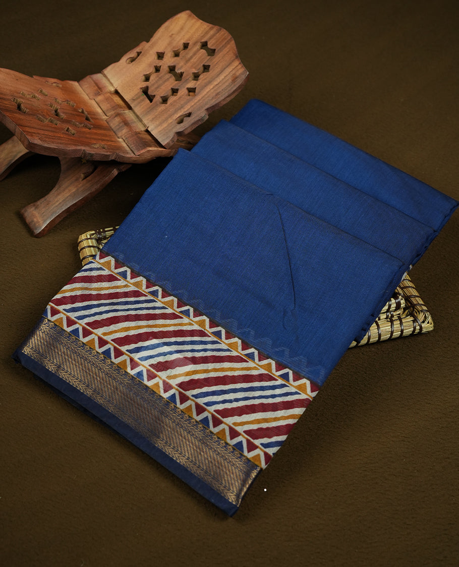 Royal blue colour chanderi cotton saree with plain body, geometric tribal printed pallu with golden zari border, and matching striped blouse.