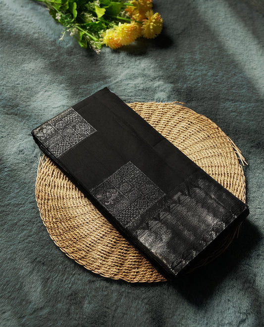 Black colour silk cotton saree adorned with a shimmering silver zari border and intricate woven designs, blending elegance with tradition, Paired with a matching blouse, its perfect for festive and special occasions.