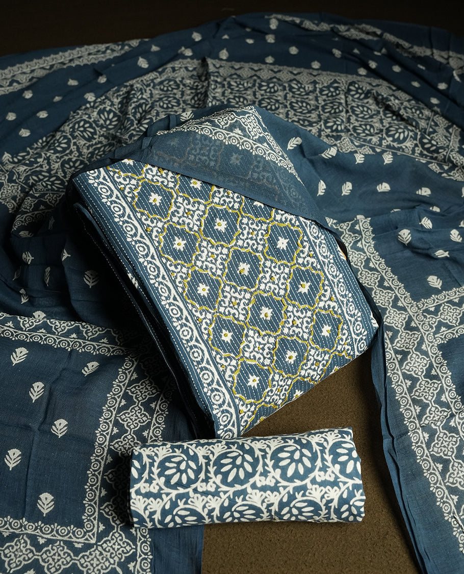 Greyish blue colour cotton churidar material featuring intricate white and mustard thread block prints on the body, complemented by a beautifully printed dupatta and matching printed fabric for the bottom.