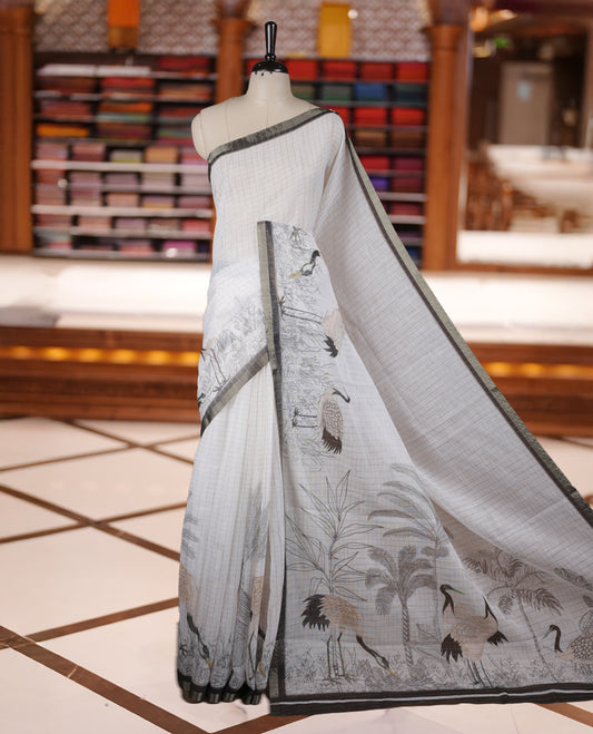 Off white colour Soft cotton saree featuring elegant bird prints along the edges, a stylish checked body, and a beautifully designed black border & Paired with a matching blouse piece.