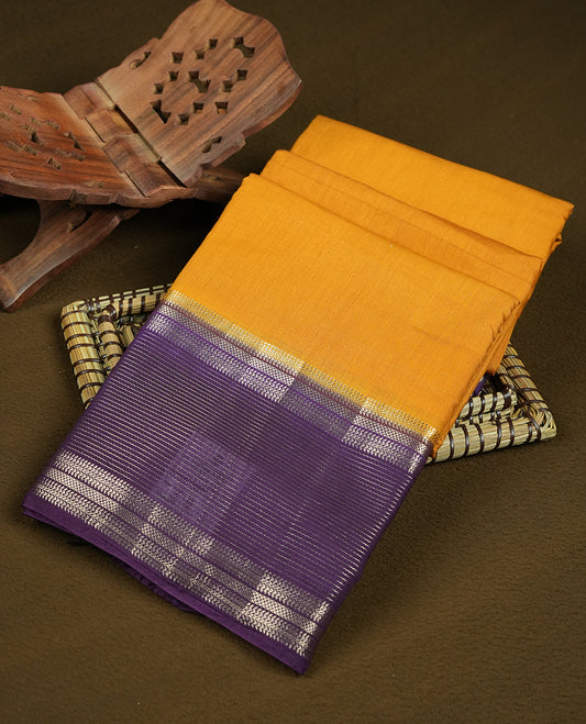 Mustard yellow colour mixed chanderi cotton saree with plain body, deep purple pallu and border with silver zari geometric motifs, and matching purple blouse.