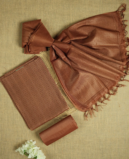 Deep brown colour tussar suit material featuring a subtle self copper zari woven motifs and vertical and stripped pattern on the body, paired with a lightweight matching dupatta with tassel edges and a plain bottom piece.