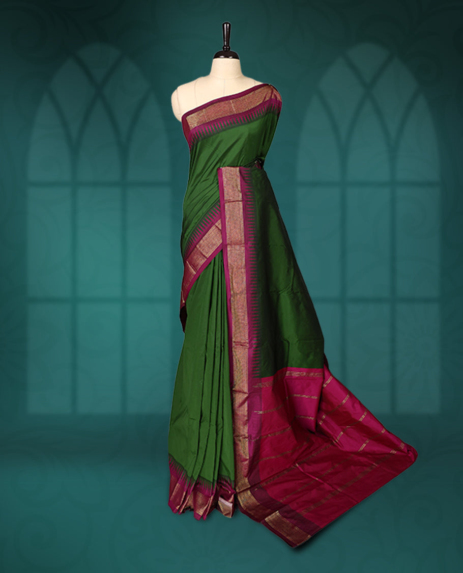 Deep green semi silk saree with plain body, vibrant deep magenta pallu and matching magenta border adorned with golden zari, accented with temple motifs along the edges, Paired with a matching blouse, perfect for festive occasions.